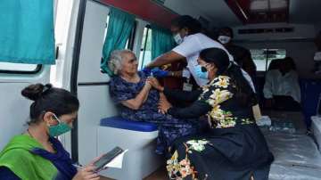 A Municipal Corporation worker administers COVID-19 vaccine to a senior citizen inside an ambulance in Thane.
