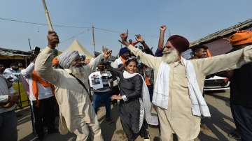 Farmers celebrate after Prime Minister Narendra Modi announced the repealing of the three Central farm laws, at Singhu Border in New Delhi, Friday, Nov. 19, 2021. 
