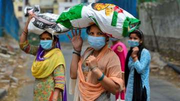 Women carry free ration collected from a fair price shop during the ongoing COVID-19 nationwide lockdown in Delhi in May last year.