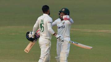 Bangladesh's Liton Das (L) is congratulated by teammate Mushfiqur Rahim after he scored a century (100 runs) during the first day of the first Test cricket match between Bangladesh and Pakistan at the Zahur Ahmed Chowdhury Stadium in Chittagong on November 26, 2021.