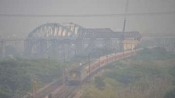 Ghaziabad: A train makes its way amid low visibility due to a thick layer of smog, in Ghaziabad on Friday