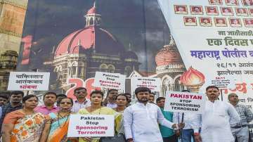 Members of Police Charitable Trust hold placards at the Gateway of India to mark the 13th anniversary of the 26/11 terror attacks, in Mumbai, Friday, Nov. 26, 2021. 