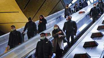 Commuters in Canary Wharf underground tube station wear face masks to curb the spread of COVID-19, now mandatory on public transport in Britain after the emergence of new Omicron variant, in London.