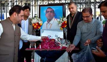 Businessmen put candles and rose petals next to the portrait of a Sri Lankan manager of a sports equipment factory, as they pay tribute to him outside the office of Sialkot Chamber of Commerce and Industry in Sialkot 