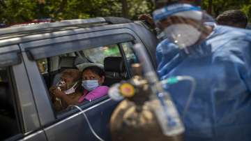 A patient in a car receives oxygen provided by a gurdwara in New Delhi