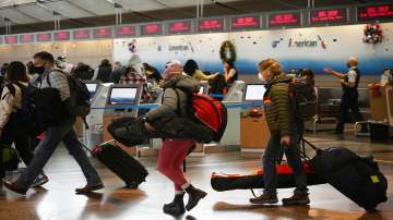 Travelers queue up at the American Airlines check-in counter at Denver International Airport, Sunday.