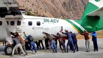 Passengers pushed the stranded twin otter aircraft belonging to Tara Air off the runway. 