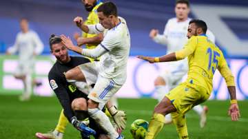 Real Madrid's Eden Hazard (in white) battle for the ball with Cadiz goalkeeper Jeremias Ledesma duri