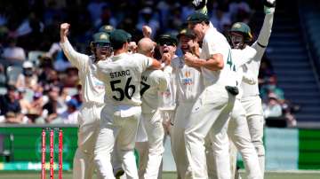 Nathan Lyon of Australia celebrates with team mates after taking the wicket of Ben Stokes of England