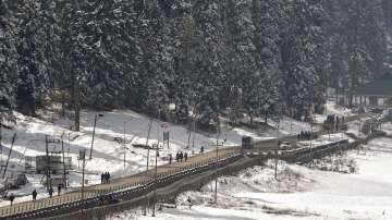 People walk on a road after a light snowfall at ski resort Gulmarg in Baramulla District of North Kashmir.