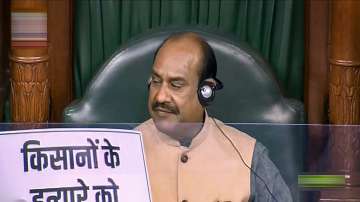LS speaker conducts proceedings as an opposition leader holds a placard during the Winter Session of Parliament. 