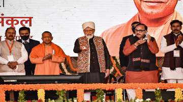 Varanasi: Prime Minister Narendra Modi launches various development projects during a public meeting at Karkhianv (Pindra), in Varanasi, Thursday, Dec. 23, 2021. UP CM Yogi Adityanath is also seen