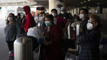 Travelers wait for a shuttle but to arrive at the Los Angeles International Airport in Los Angeles on Monday (Dec. 20).