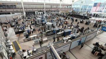 Travelers queue up at the south security checkpoint in the terminal of Denver International Airport Sunday, Dec. 26, 2021, in Denver.?