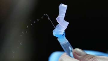 A health worker prepares for a vaccine dose.