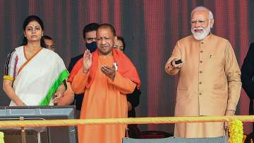 Prime Minister Narendra Modi, UP Chief Minister Yogi Adityanath and Union Minister Anupriya Patel at an event in Prayagraj on Tuesday, Dec. 21, 2021. 