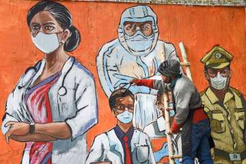 An artist gives final touches to a wall mural during the weekend curfew imposed by the Delhi government to curb the spread of Covid-19, in New Delhi