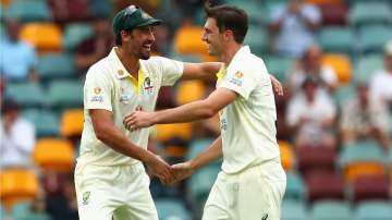 Australian captain Pat Cummins celebrates with Mitchell Starc after dismissing Chris Woakes.