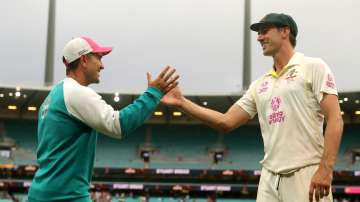 Head coach Justin Langer shakes hands with Pat Cummins of Australia after the match ended in a draw 