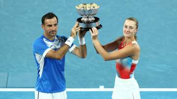 Ivan Dodig of Croatia and Kristina Mladenovic of France pose with the champions trophy.