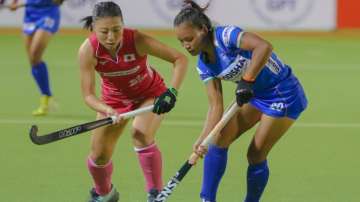 Indian forward Lalremsiami (in blue) vies for the ball with a Japanese player during Women's Hockey 
