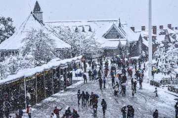 Tourists at the snow-covered Ridge during heavy snowfall in Shimla