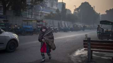 An Indian woman wrapped in a shawl walks on a cold morning in New Delhi.