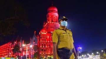 A police official stands in front of the illuminated Brihanmumbai Municipal Corporation (BMC).