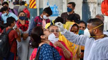 A healthcare worker collects swab sample of a passenger for Covid-19 test, at Dadar railway station, in Mumbai.