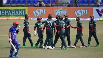 Bangladesh's cricketers celebrate after the dismissal of Afghanistan's Rahmanullah Gurbaz (left) dur