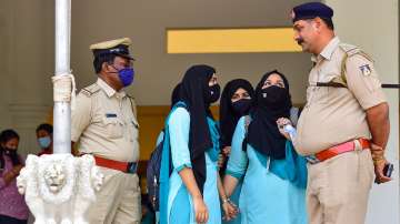 Students talk to a police officer as they leave after not being allowed to enter the PU College while wearing Hijab, in Udupi, Wednesday, Feb. 16, 2022. 