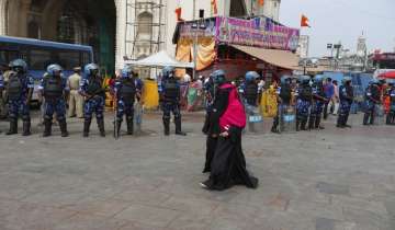 Indian Muslim women walk past paramilitary soldiers deployed as a precaution measures during the Friday prayers and ahead of a protest against banning Muslim girls wearing hijab from attending classes at some schools in the southern Indian state of Karnataka.