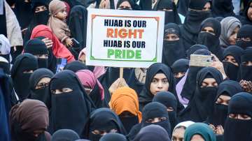 A woman holds a placard during a protest in support of female Muslim students of Karnataka over hijab issue, in Thane, Sunday, February 13, 2022.
