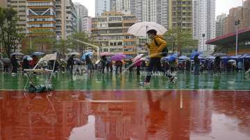 Residents line up to get tested for the coronavirus at a temporary testing center despite the rain in Hong Kong.