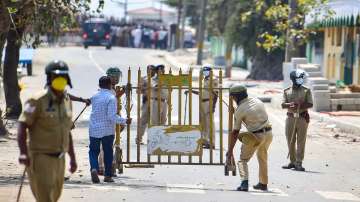 Police personnel barricade a road in front of a mosque, as tension spread in Karnataka's Shivamogga town over the murder of a member of Bajrang Dal.