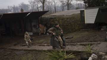 Ukrainian solders walk at an air defence base after an apparent Russian strike in Mariupol, Ukraine, Thursday, Feb. 24, 2022. 