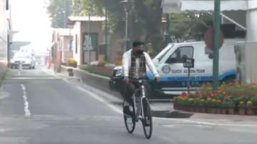Union Health Minister Mansukh Mandaviya rides a bicycle to Parliament in New Delhi.