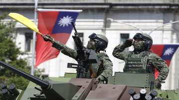  
FILE - Taiwanese soldiers salute during National Day celebrations in front of the Presidential Building in Taipei, Taiwan on Oct. 10, 2021. As Russia presses ahead with its attack on Ukraine, many analysts and internet users have drawn comparisons to Taiwan, another place that could face an invasion by its larger neighbor, in this case China.