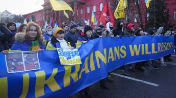 Ukrainians attend a rally in central Kyiv, Ukraine, Saturday, Feb. 12, 2022, during a protest against the potential escalation of the tension between Russia and Ukraine.