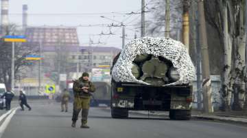 A Ukrainian soldier stands next to a military vehicle on a road in Kramatosrk, eastern Ukraine, Thursday, Feb. 24, 2022.