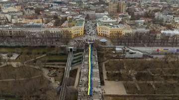 Demonstrators holding a huge Ukrainian flag march along the street in Odessa, Ukraine, Sunday, Feb. 20, 2022. 