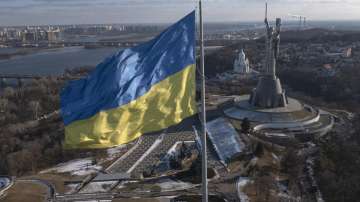 A view of Ukraines national flag waves above the capital with the Motherland Monument on the right, in Kyiv Sunday, Feb. 13, 2022.