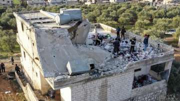 People inspect a destroyed house following an operation by the U.S. military in the Syrian village of Atmeh, in Idlib province, Syria, Thursday, Feb. 3, 2022.