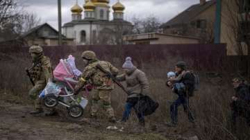 Ukrainian soldiers help a fleeing family crossing the Irpin river on the outskirts of Kyiv, Ukraine.