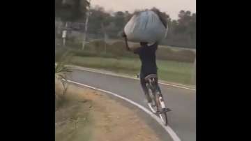 Man rides bicycle with amazing sense of balance.