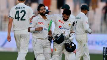 Pakistan's Azhar Ali congratulates teammate Imam-ul-Haq, while they walk back to the pavilion at the