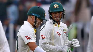 Australia's Usman Khawaja, right, and David Warner walks back to pavilion on the end of the second d