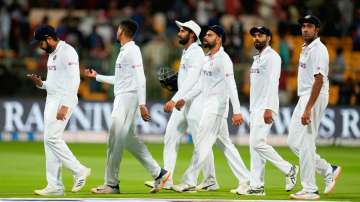 Indian players led by captain Rohit Sharma, left, leave the field at the end of play on the first da