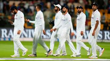 Indian players led by captain Rohit Sharma, left, leave the field at the end of play on the first da