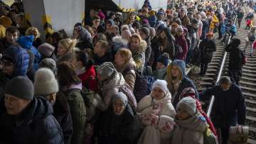 People crowd as they try to get on a train to Lviv at the Kyiv station, Ukraine, Friday, March 4. 2022. 